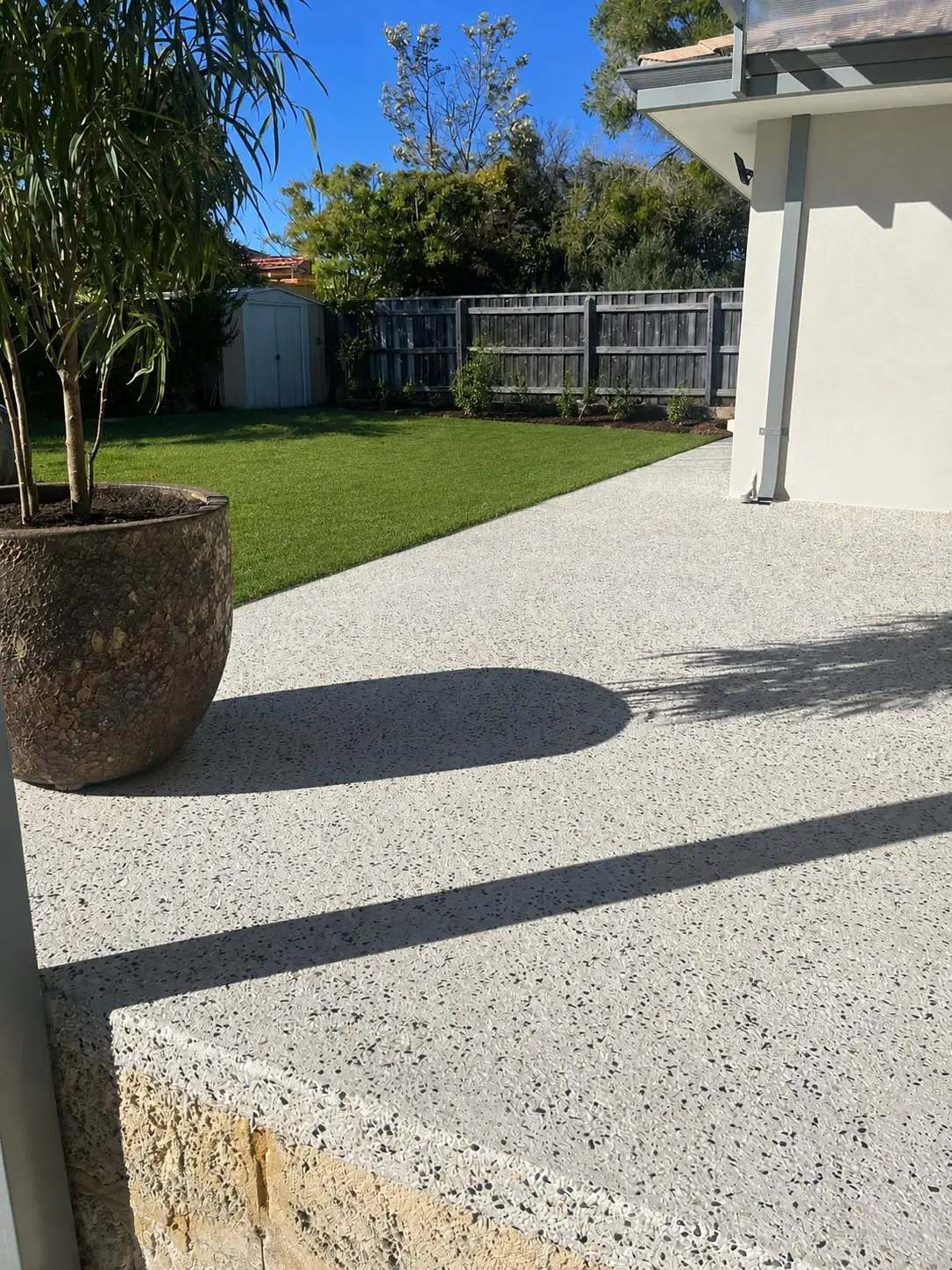 Exposed aggregate patio stepping down to lawn